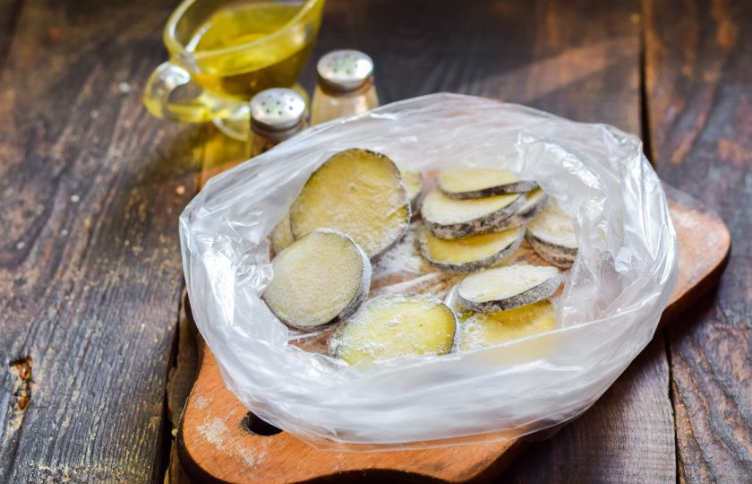 1. Этап. Хрустящие баклажаны с помидорами и кинзой: Переложите баклажаны в чистый пакет, всыпьте немного муки и хорошо перемешайте, чтобы каждый кусочек баклажана был покрыт мукой.