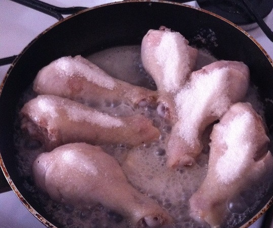 1. Этап. Курица по-корейски: Через 15 минут открываем крышку и высыпаем на каждый кусочек курицы по столовой ложке сахара. Снова накрываем крышкой и тушим в течение 10 минут. За это время сахар должен карамелизоваться.