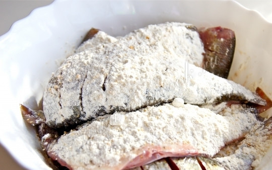 1. Этап. Плотва жареная: Муку смешайте с солью, чёрным молотым перцем. Обваляйте плотву в муке.