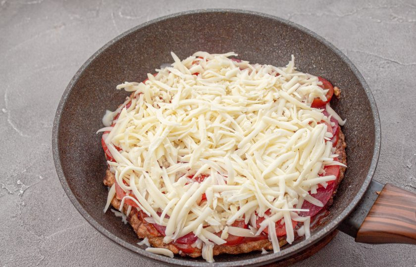 1. Этап. Пицца из кабачков без муки на сковороде: Посыпьте все тертым сыром и готовьте под крышкой еще 5-7 минут, до его расплавления.