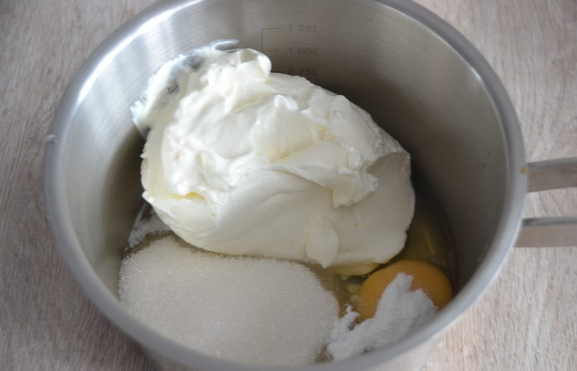 1. Этап. Эклеры со сметанным кремом: Сначала займитесь приготовлением крема. Для этого выложите в сотейник 1 яйцо, 120 грамм сахара и сметану. Все хорошо перемешайте.