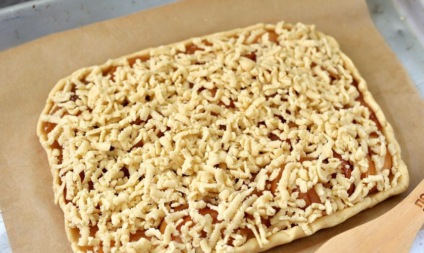 1. Этап. Тертый пирог с вареньем на маргарине: Натрите на крупной терке слегка подмерзшую вторую часть теста так, чтобы она практически полностью прикрывала слой яблочных долек. Отправьте противень в предварительно разогретую до 190 градусов духовку в режиме верхнего и нижнего нагрева минут на 20-25. Но лучше следить за своей техникой. Как только крошка на пироге хорошо зарумянится — он готов.