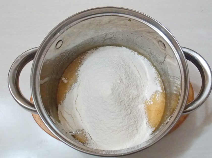 1. Этап. Медово-песочный торт: Просейте муку через мелкое сито в кастрюлю с медовой массой.