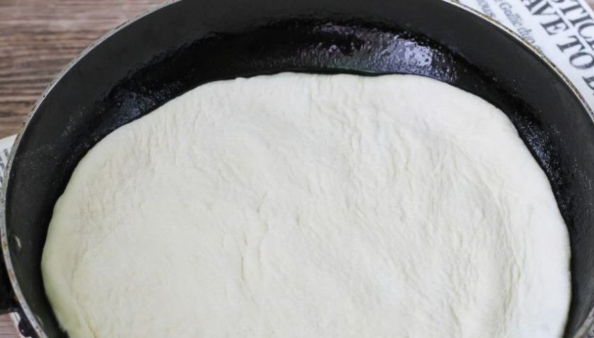 1. Этап. Домашняя пицца на тонком тесте: Смажьте сковородку растительным маслом и разогрейте на плите. Затем раскатайте тесто в тоненький пласт и вырежьте из него круг по размеру сковороды. Остатки теста можно положить в морозилку. Выложите корж на сковороду.