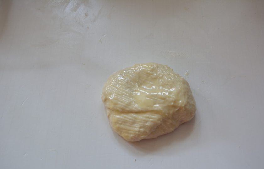 1. Этап. Роти Канай: Далее нам понадобится большая поверхность. Смажьте тонким слоем масла столешницу. Выложите на нее лепешку. Верхнюю часть лепешки смажьте растопленным сливочным маслом.