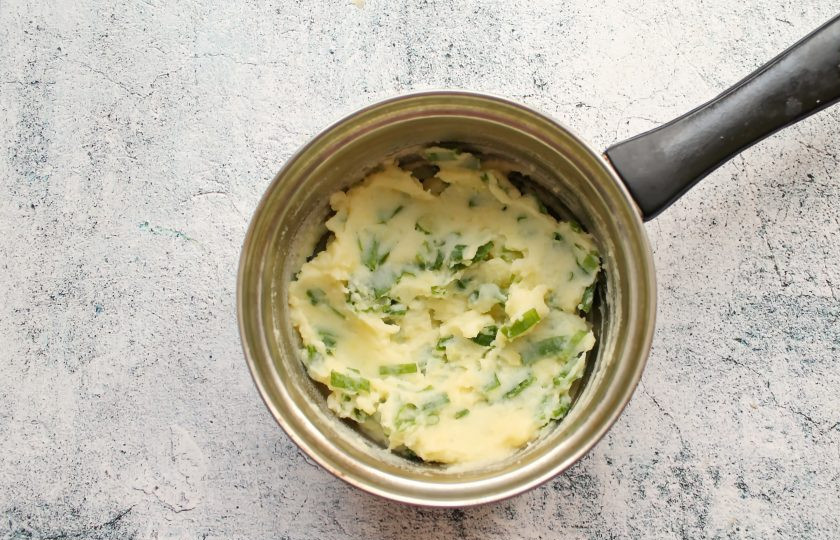 1. Этап. Пирожки Два в одном: Зеленый лук порежьте, добавьте в картофельное пюре и перемешайте. При необходимости досолите.