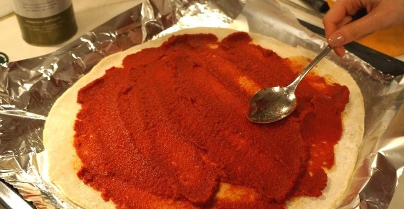 1. Этап. Творожная пицца: Тесто раскатайте при помощи скалки, постоянно посыпая её и рабочую поверхность мукой. Раскатанное тесто аккуратно уложите в противень. Я устилаю противень фольгой и немного присыпаю её мукой. Тесто смажьте томатной пастой и насыпьте сверху приправы.