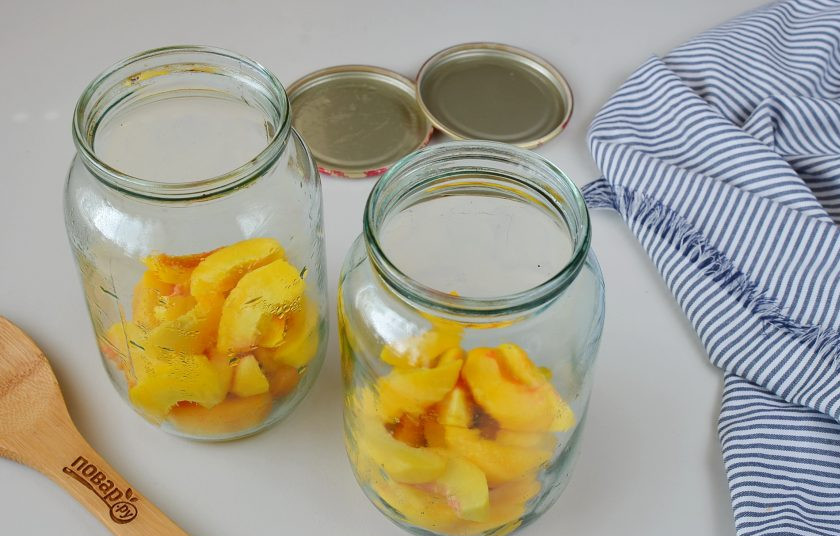 1. Этап. Компот из персиков: В стерильные банки выложите по 250 грамм персиков.