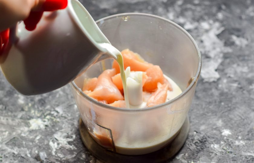 1. Этап. Домашняя колбаса для детей: Влейте к курице порцию сливок.