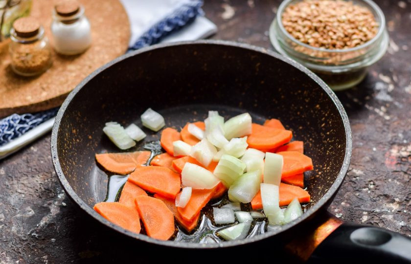 1. Этап. Гречка с фаршем и грибами: Очистите морковь и луковицу, овощи сполосните и просушите, нарежьте морковь небольшими брусками, луковицу нарежьте кубиками небольшого размера. Прогрейте сковороду, влейте ложку масла, переложите овощи.