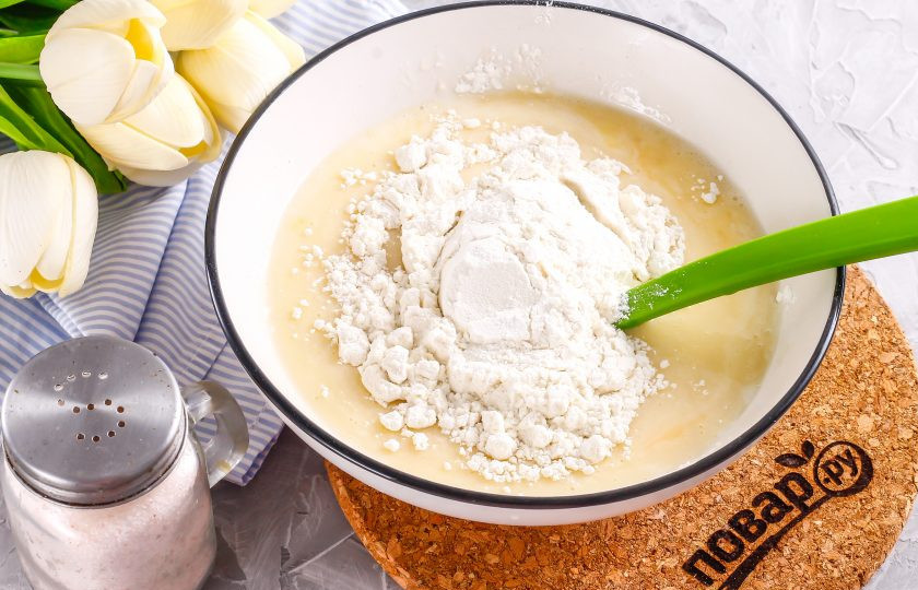 1. Этап. Оладьи с нутеллой: Всыпьте разрыхлитель и пшеничную муку высшего сорта, аккуратно вмешайте сухие ингредиенты в яичную массу. Если разрыхлителя нет в наличии, то замените его 1/4 ч.л. соды, гашеной уксусом.