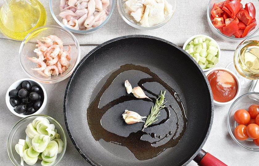 1. Этап. Рагу из морепродуктов: В сковороде с толстым дном разогрейте оливковое масло с веточкой розмарина и придавленным ножом чесноком в шелухе.