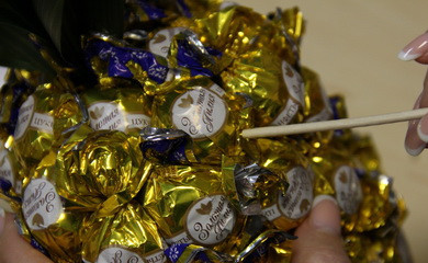 1. Этап. Ананас из конфет: 10. Чтобы ананас из конфет в домашних условиях был гладким, после прикрепления всех конфет можно аккуратно заправить хвостики в основу. Вот и все, удивительный подарок готов!