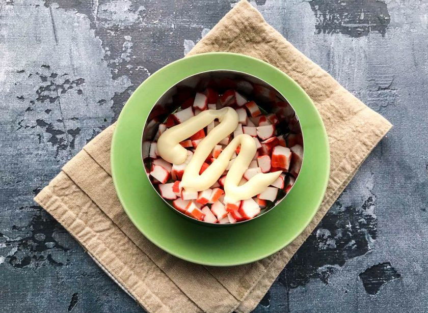 1. Этап. Салат Безумный с крабовыми палочками: Крабовые палочки смажьте небольшим количеством майонеза.