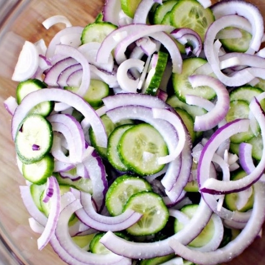 1. Этап. Салат из огурцов в сметанном соусе: Кладем огурцы и лук в миску, посыпаем их солью и оставляем минут на 10-15. За это время овощи отдадут немного сока, который нам не нужен - его нужно будет слить.