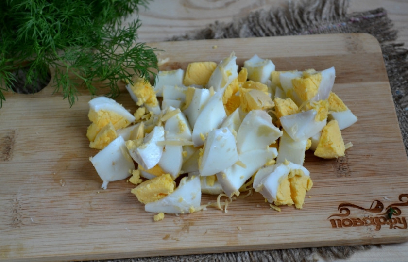 1. Этап. Салат из шпрот: Яйца отварите вкрутую (советую сделать это заранее) и порежьте крупными кусочками. Особенность этого салата - в крупно порезанных ингредиентах, таким образом каждый из них хорошо чувствуется.