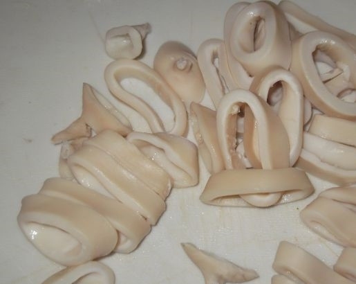 1. Этап. Кольца кальмаров в кляре: 1. Перед тем, как приготовить кольца кальмаров в кляре, разморозьте тушки кальмаров в холодной воде. Возьмите кастрюлю, налейте воду. После того, как она закипит, опустите туда тушки моллюсков. Варите не более трех минут. Остудите готовый морепродукт и нарежьте кольцами, шириной примерно 1 см. Обсушите бумажным полотенцем.