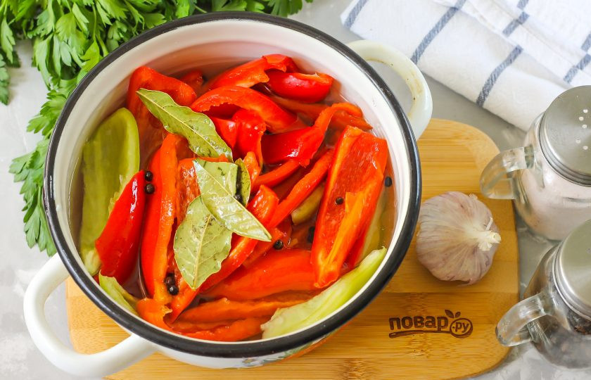 1. Этап. Маринованные перцы быстрого приготовления с маслом: Выложите нарезку болгарского перца в другую емкость. Очистите от шелухи чесночный зубчик и промойте его, нарежьте в емкость, залейте все кипящим маринадом. Оставьте на 30-40 минут до полного остывания, время от времени перемешивая содержимое емкости для равномерного приготовления.