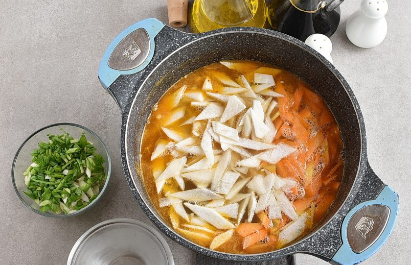 1. Этап. Корейский суп: Опустите в суп нашинкованные овощи и варите минут 5, пока дайкон не станет полупрозрачным.