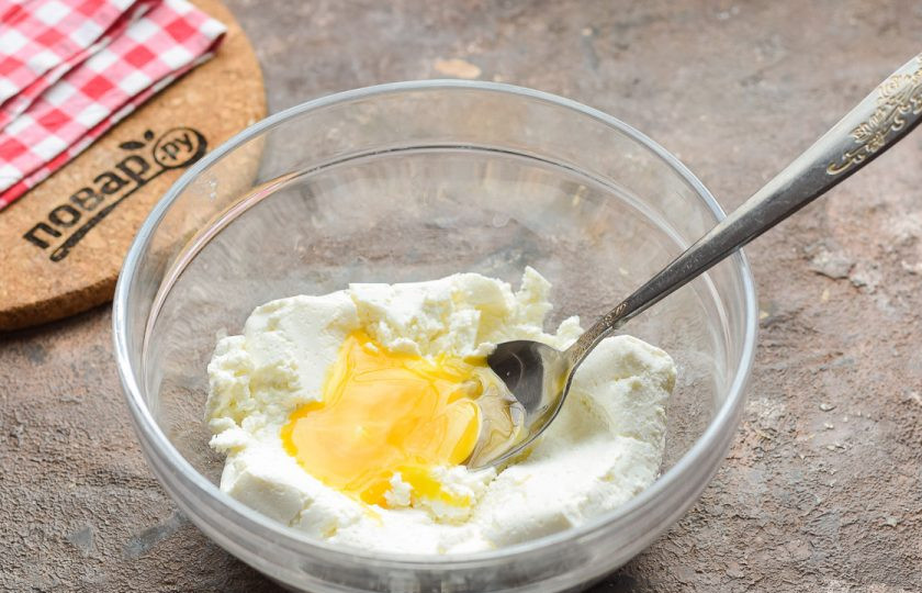 1. Этап. Сырники с какао: В миску переложите творог и вбейте куриное яйцо, добавьте щепотку соли.