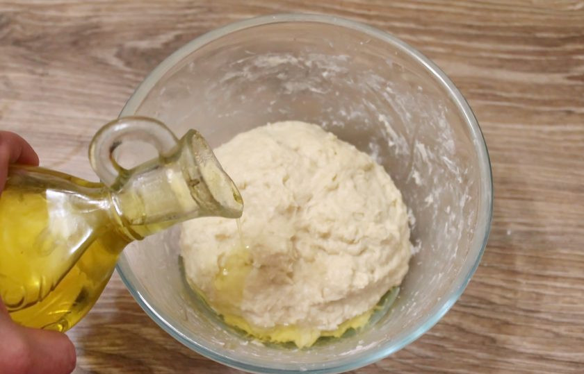 1. Этап. Ватрушки с черникой: Влейте в тесто растительное масло и хорошенько замесите гладкое, нежное тесто. Вымешивайте тесто не менее 10 минут, выложив его на стол.