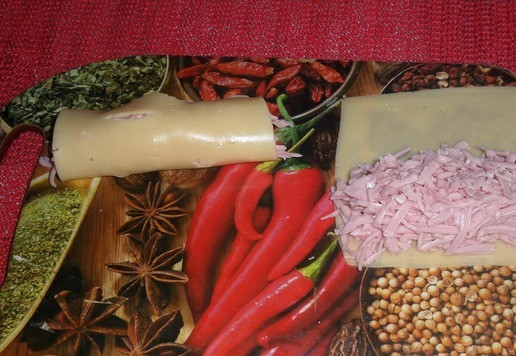 1. Этап. Хот-дог с колбасой и сыром: На ломтики сыра выкладываем измельченную вареную колбасу и скручиваем в виде трубочки.