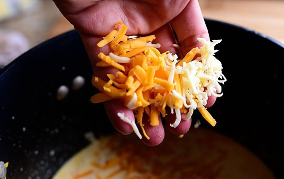 1. Этап. Сырный дип для овощей: 3. Натрите сыр на терку и добавьте к горячему молоку, перемешивайте, пока сыр не расплавится.