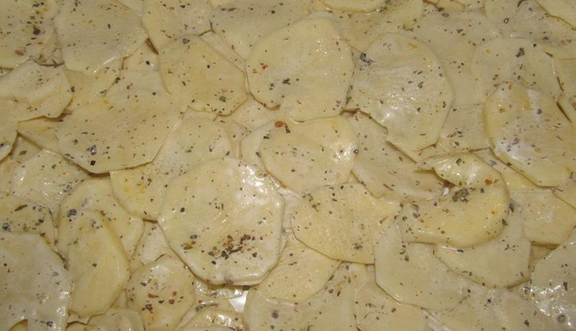 1. Этап. Картошка, запеченная со свининой и сыром: Противень застилаем фольгой и смазываем маслом. Выкладываем на противень ломтики тонко порезанного картофеля, сверху присыпаем его любимыми специями — солью и перцем.