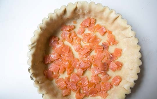 1. Этап. Заливной пирог с лососем: 6. Нарежьте лосось небольшими кусочками. Выложите половину рыбы.
