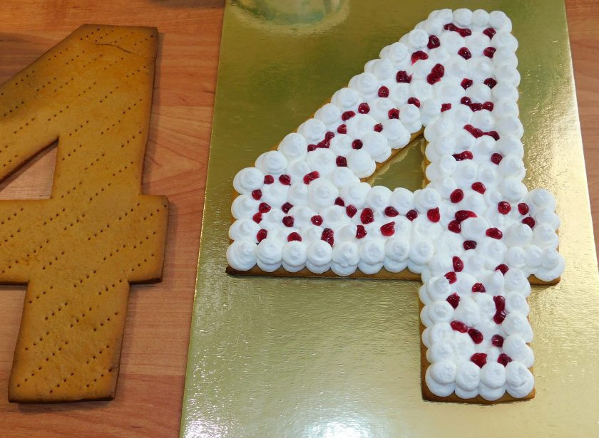 1. Этап. Медовый открытый торт Цифра: Между коржами отсадите аккуратно крем с помощью круглой насадки. В промежутках добавьте немного конфитюра. По верхнему коржу – только крем. Затем уберите торт в холодильник, чтобы он пропитался. Лучше всего его держать в закрытой таре, чтобы он не высыхал.