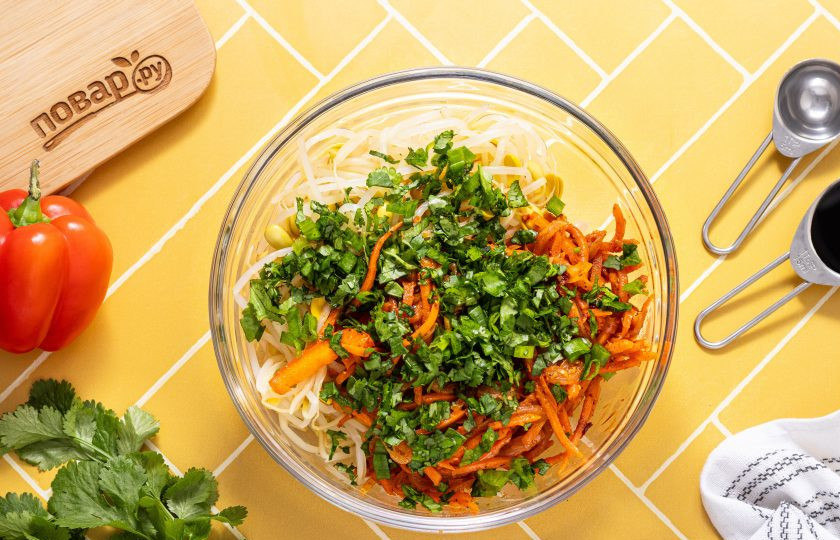 1. Этап. Салат из пророщенной сои по-корейски: Добавьте мелко нарезанную кинзу и зеленый лук. Влейте соевый соус, уксус и рыбный соус.