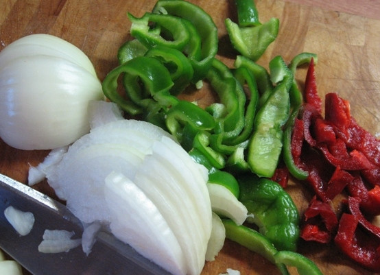 1. Этап. Баклажаны, жаренные со свининой: Очищаем лук и перец. Нарезаем лук полукольцами, перец нарезаем чуть крупнее, чем лук.