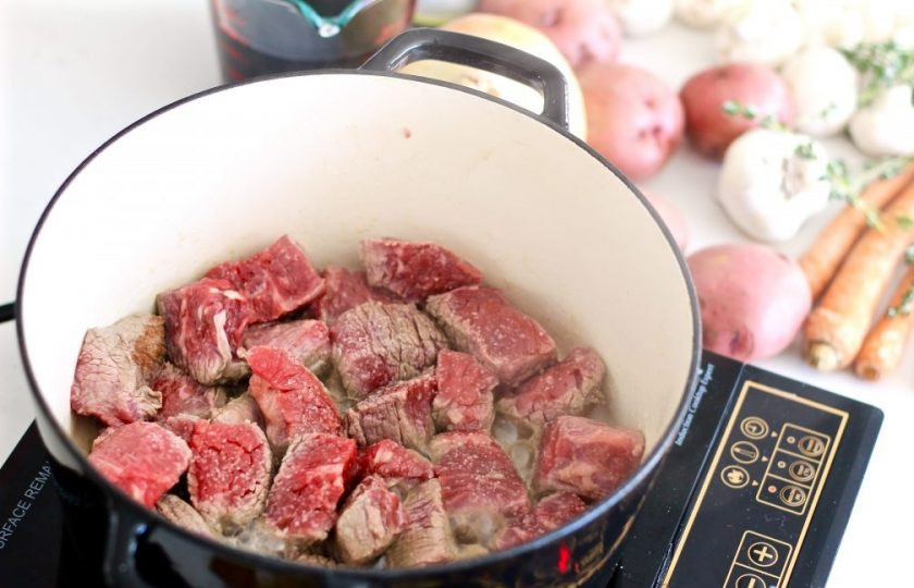 1. Этап. Говядина в вине в духовке: 1. Вымойте и нарежьте мясо небольшими кусочками. Разогрейте кастрюлю с растительным маслом и выложите мясо.