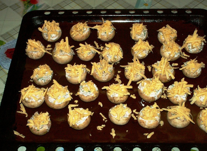 1. Этап. Грибы, запеченные с сыром в духовке: Выложите их на противень, посыпьте тертым сыром и запеките в духовке в течение 15-20 минут. Подавайте в горячем виде.