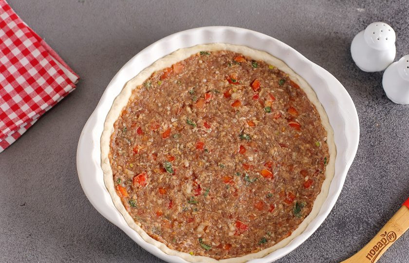 1. Этап. Восточная пицца: Сверху тонким слоем намажьте тесто фаршем.