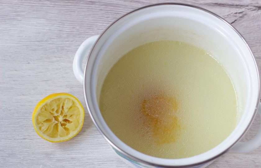 1. Этап. Аспик из курицы и овощей: Перелейте бульон в небольшую кастрюлю, выдавите в него сок половины лимона и добавьте желатин.