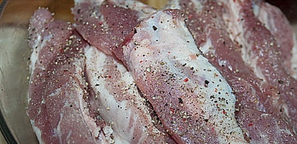 1. Этап. Жареные ребрышки на сковороде: 3. Далее солим и перчим мясо, всыпаем специи и сухие травки. Добавляем измельченный чеснок, оливковое масло и бальзамический уксус. Тщательно растираем и перемешиваем ребрышки, чтобы они равномерно покрылись маринадом. Затем накрываем посуду с мясом крышкой и ставим в укромное место на 1 час, чтобы оно хорошенько замариновалось. В течение этого часа несколько раз перемешиваем ребрышки.