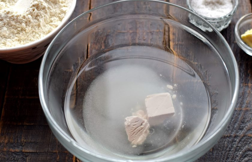 1. Этап. Булочки Столичные: Воду нагрейте до теплого состояния, залейте прессованные дрожжи, добавьте сахар.