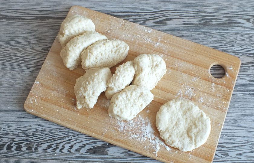 1. Этап. Пышки с яблоками: Готовое тесто должно получиться мягким, хорошо держать форму, но не быть забитым мукой. Долго не месите его. Как только образовался однородный комок, скатайте из него валик и поделите его на 8 равных частей. Подпылите мукой рабочую поверхность. Каждую часть разомните в круглую лепешку толщиной не более 1 см.