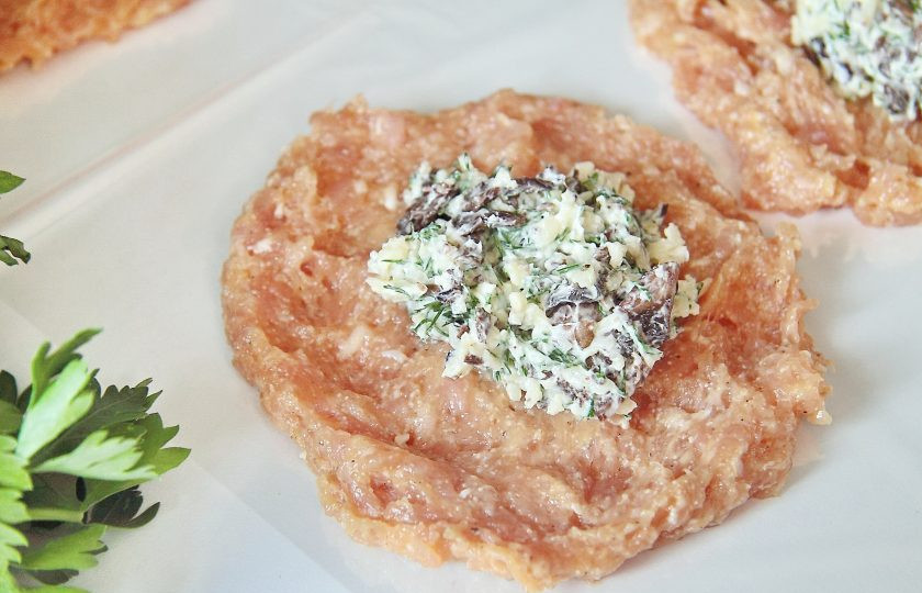 1. Этап. Котлеты по-мински: 5. Фарш разделите на восемь равных частей и выложите на застеленный пищевой пленкой стол, я использовала пакет для запекания. Мокрой рукой придайте фаршу формы лепешек, положите по центру начинку.