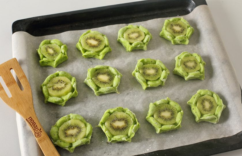 1. Этап. Печенье с киви: В середину выложите по кружочку киви и загните края кверху. Я еще для надежности соединила края между собой. Готовьте печенье в духовке при температуре 180 градусов около 10 минут. Печенье выпекается быстро, не пересушите его.