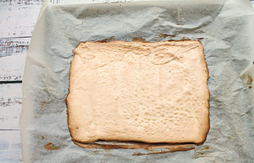 1. Этап. Меренговый рулет с творожным кремом: Поставьте противень в горячую духовку и выпекайте при температуре 160 градусов в течение 30-35 минут. Готовый корж достаньте из духовки, переверните на чистый пергамент и снимите нижний. Оставьте корж до полного остывания.