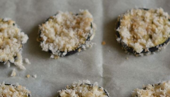 1. Этап. Баклажаны, запеченные с чесноком: Выложите баклажаны в панировке на противень, застеленный пергаментом. Поставьте в духовку, разогретую до ста девяноста градусов, и запекайте двенадцать-пятнадцать минут.