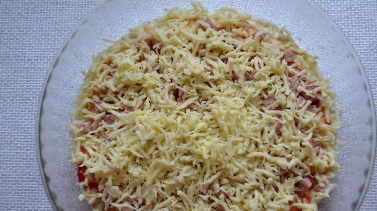 1. Этап. Пицца без дрожжей на кефире: 8. Натрите на крупной терке твердый сыр и посыпьте пиццу.
