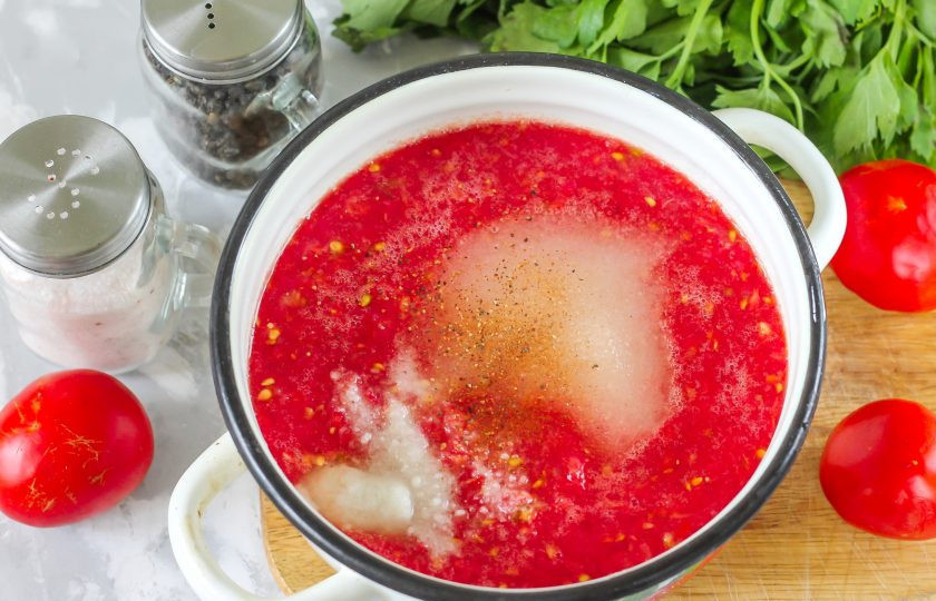 1. Этап. Приправа из помидоров на зиму: Перелейте томатную массу в кастрюлю или казан, добавьте соль, сахар и молотый черный перец.