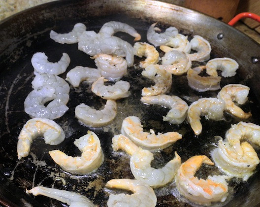 1. Этап. Черная паэлья: 1. Для начала на сковороде необходимо разогреть 1 ложку оливкового масла и отправить туда креветки. Обжарить их немного (не до готовности) и переложить на тарелку.