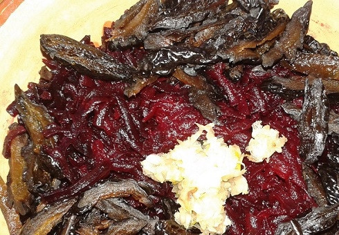 1. Этап. Салат с грецким орехом и черносливом: Добавляем к свекле чернослив и чеснок, соль и перец. Перемешиваем.