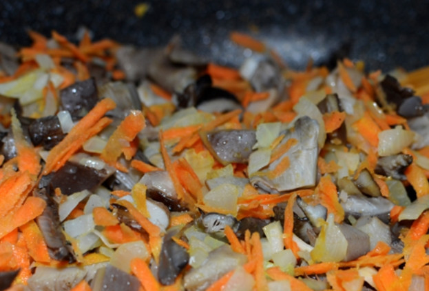 1. Этап. Перловка с вешенками: Вешенки промываем и нарезаем пластинками. Обжариваем несколько минут на растительном масле. Добавляем к грибам порезанный лук и тертую морковь. Перемешиваем и жарим вместе до готовности.