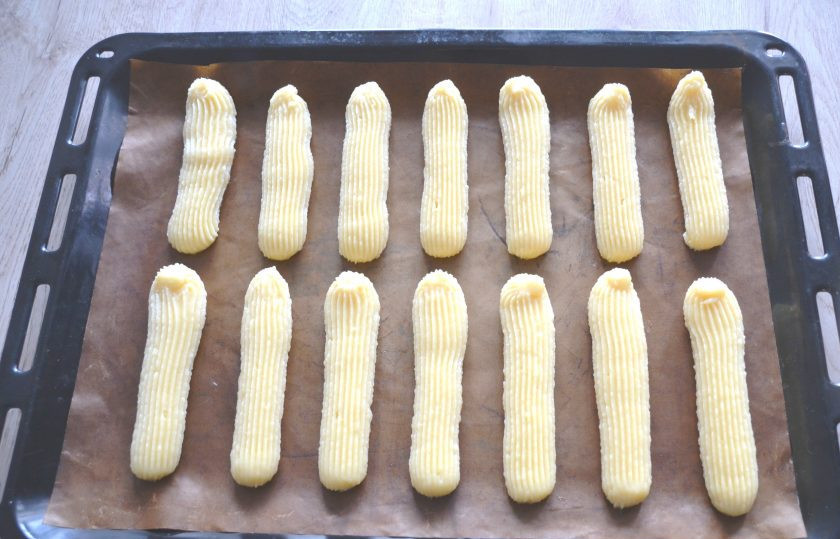 1. Этап. Крем Пломбир для эклеров: Переложите тесто в кондитерский мешок, отсадите эклеры на лист для выпечки.