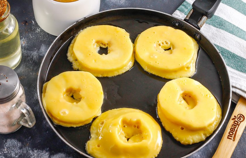 1. Этап. Жареные яблочные кольца: Прогрейте растительное масло на сковороде при умеренном нагреве примерно 2 минуты, затем выложите кольца в кляре, но только в кипящее масло, чтобы кляр сразу же обжарился.